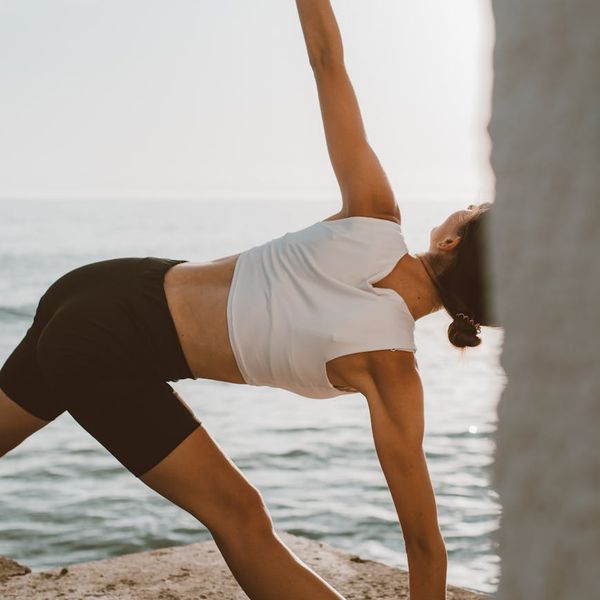 Person stretching outdoors during sunrise feeling energized.